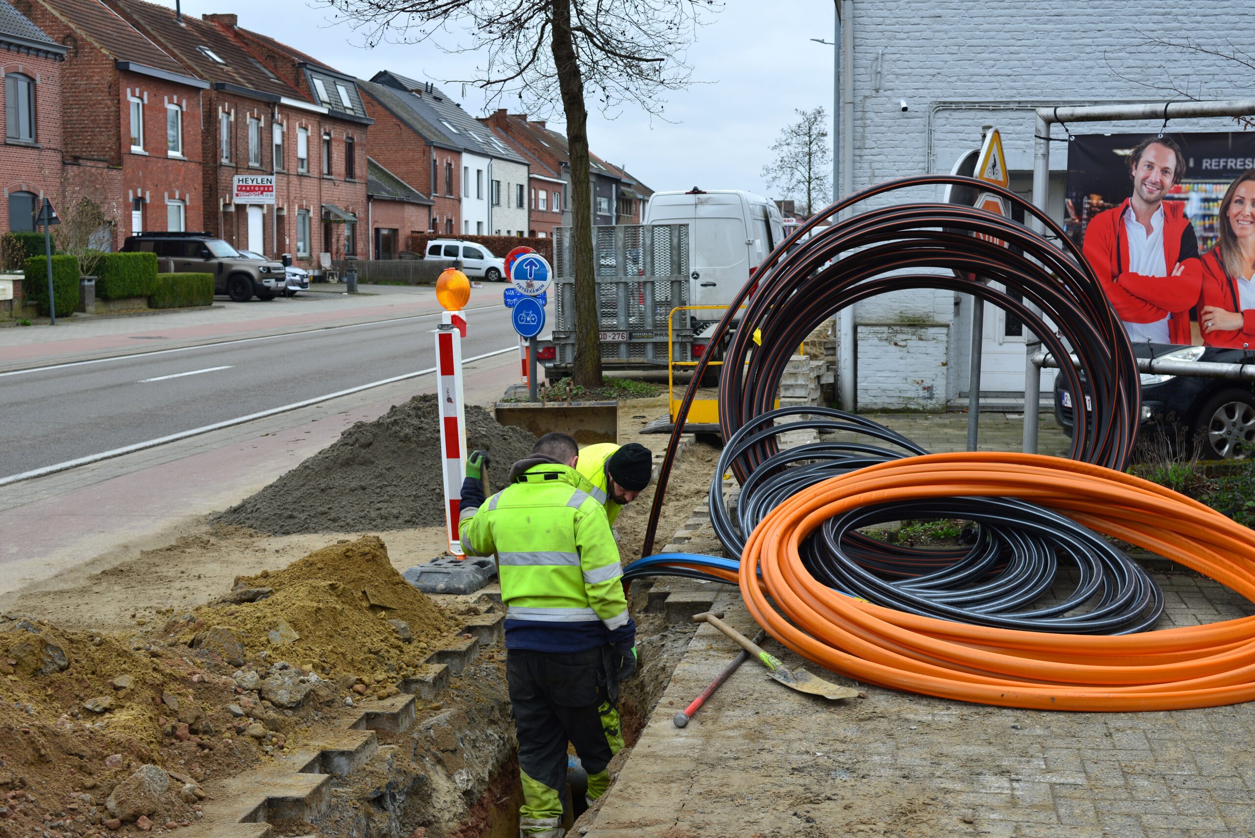 Photo de techniciens de génie civil dans une tranchée occupés à poser des conduits pour tirer des fibres optiques 
