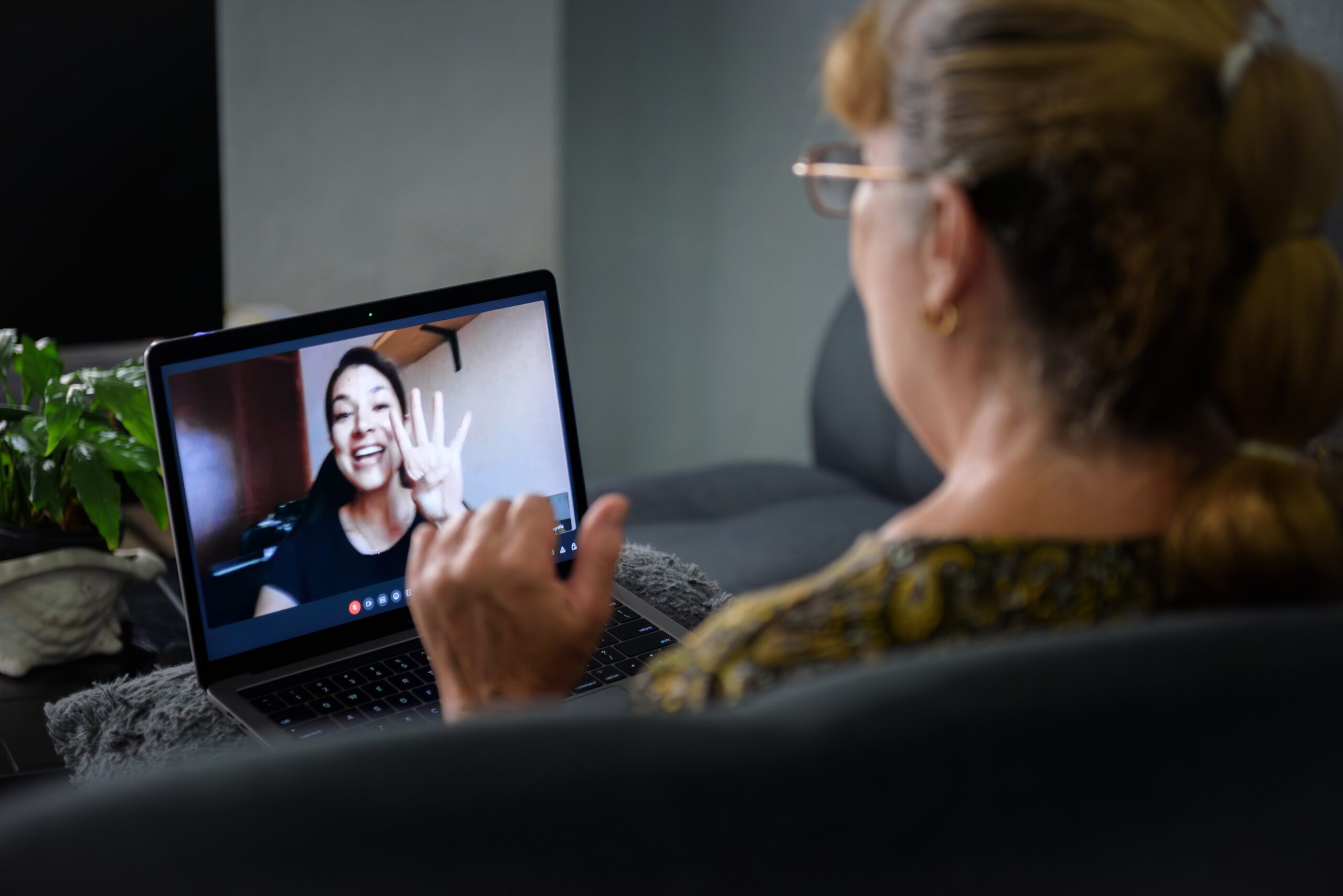 Photo of a woman in her sixties talking to her daughter via a video call on a laptop 